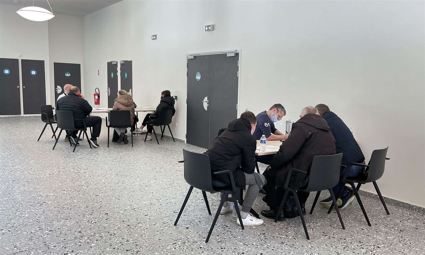 Ukrainian refugees who have fled the conflict sit with British government officials fill out paperwork as they seek to enter the UK, at the ferry terminal in Calais, France (Gareth Fuller/PA)