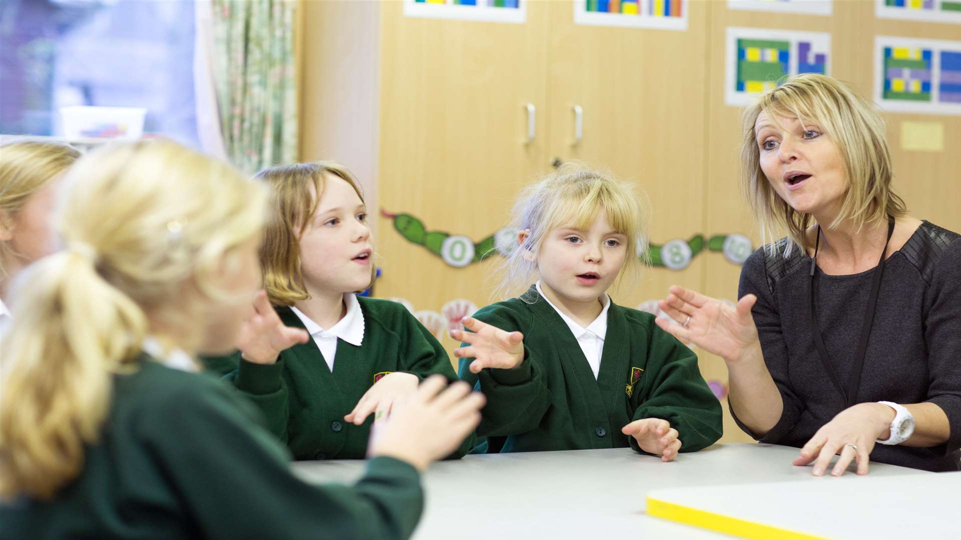 Susie Martin signs with pupils Georgia Molly, Annabel and Maisie