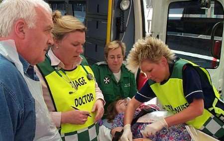 The "injuries" sustained by a "casualty" are assessed as she is removed from an ambulance