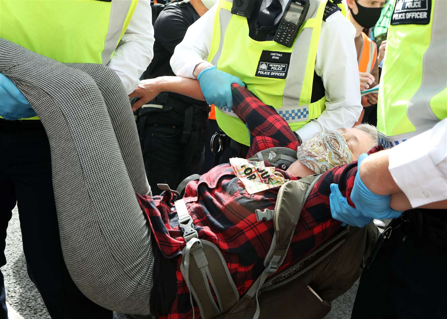 An Extinction Rebellion protester is removed by police officers near Parliament Square (Luciana Guerra/PA)