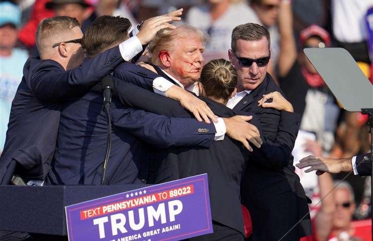 Former president Donald Trump is helped off the stage at a campaign event. Picture: Gene J Puskar/AP