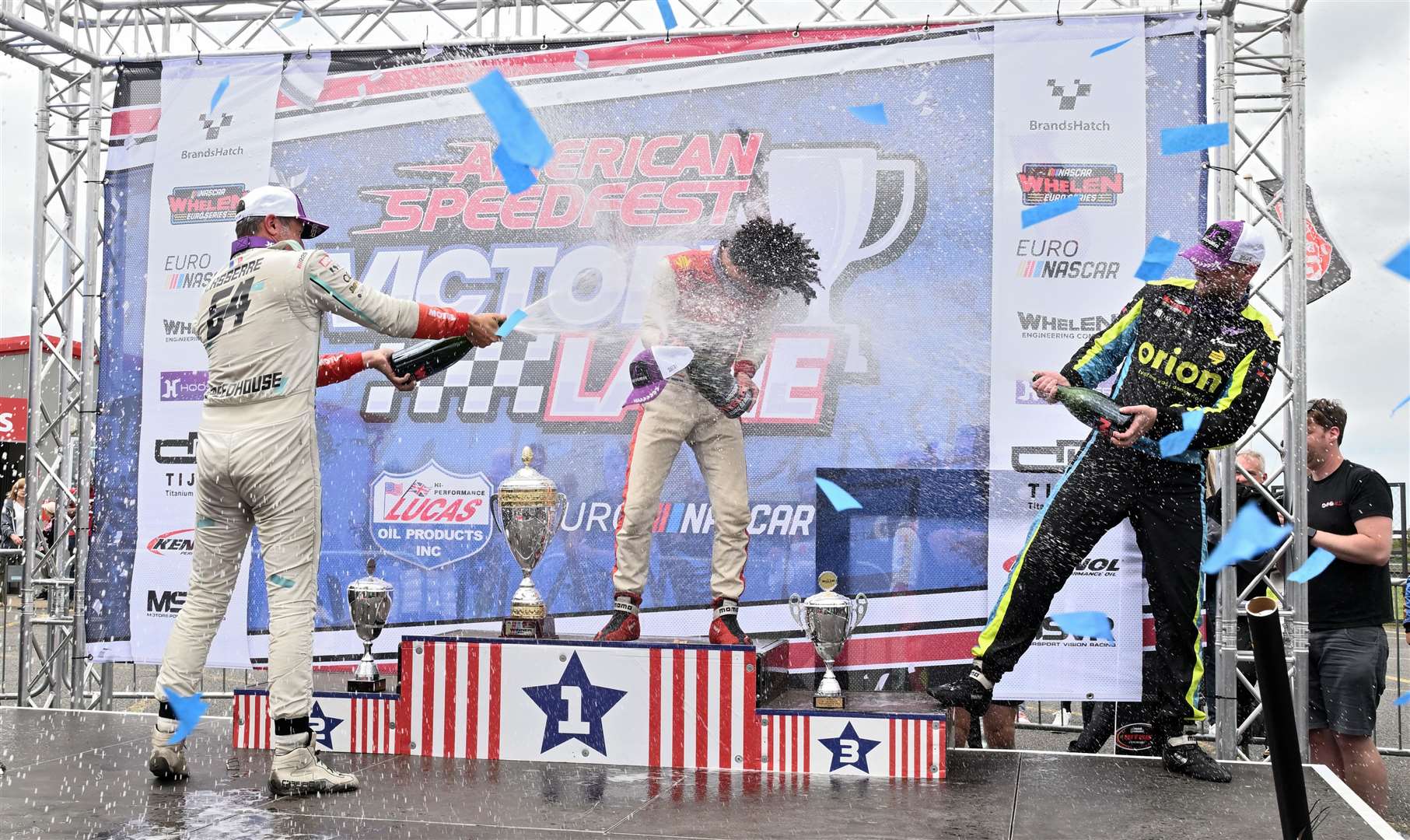 Hezemans, centre, celebrates winning Sunday’s EuroNASCAR Pro race, getting a champagne soaking from Lucas Lasserre and Martin Doubek. Picture: Simon Hildrew