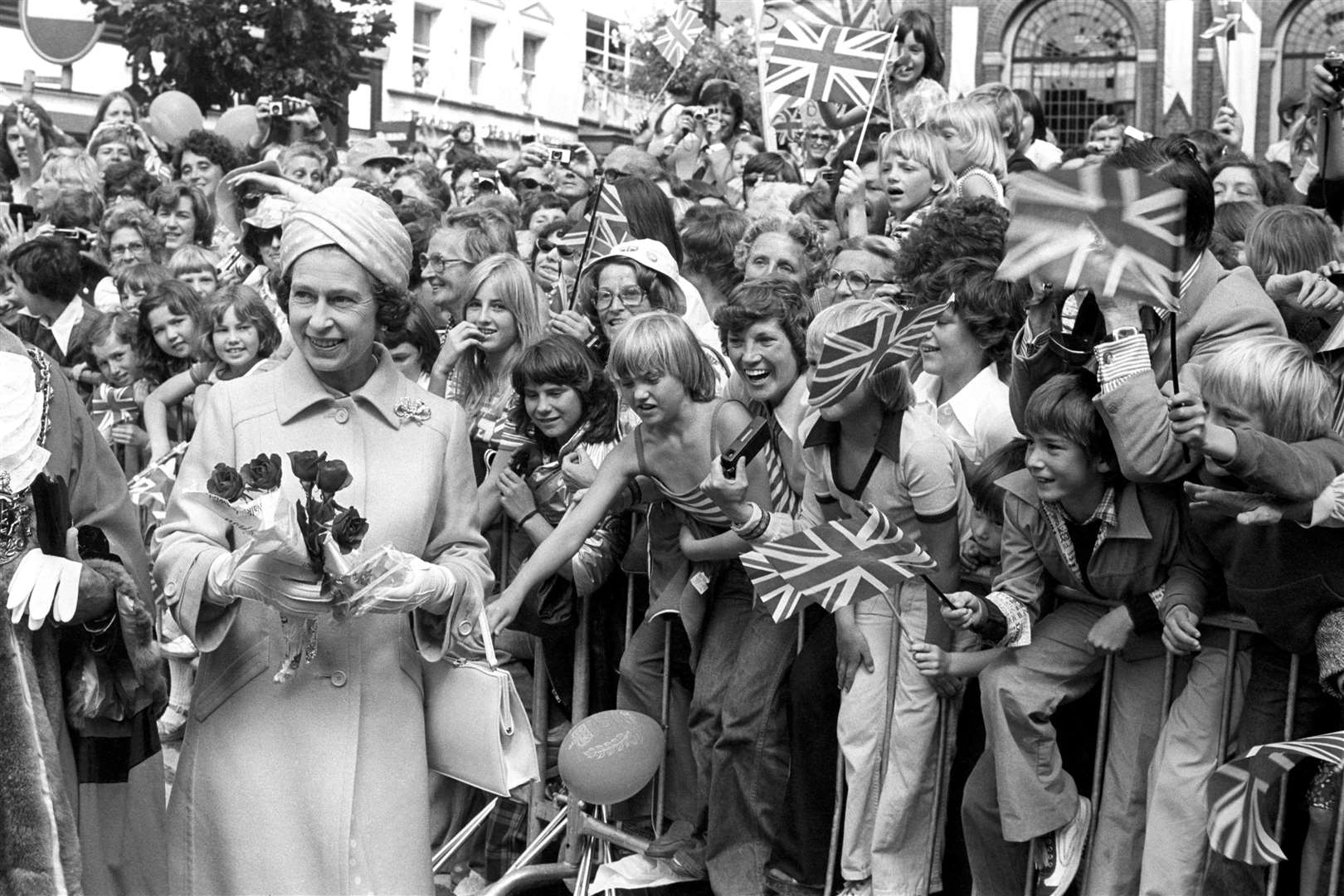 The Queen receives flowers during a walkabout in Ipswich, during her Silver Jubilee Tour of Britain (PA)