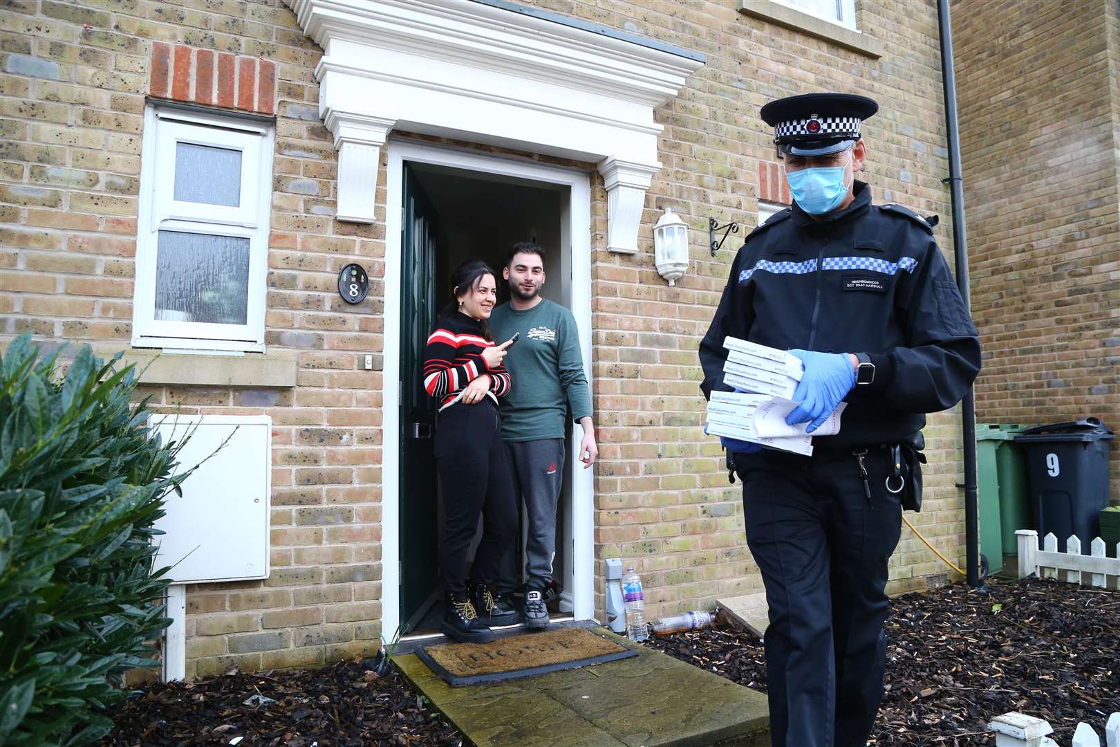 A Police Community Support Officer takes away completed coronavirus testing kits during a testing blitz (Gareth Fuller/PA)