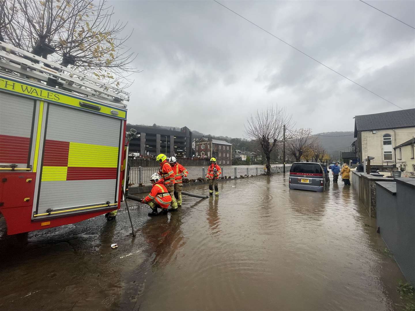 Firefighters pumping water from a street by the River Taff, in Pontypridd, Wales, following flooding on Sunday (George Thompson/PA)