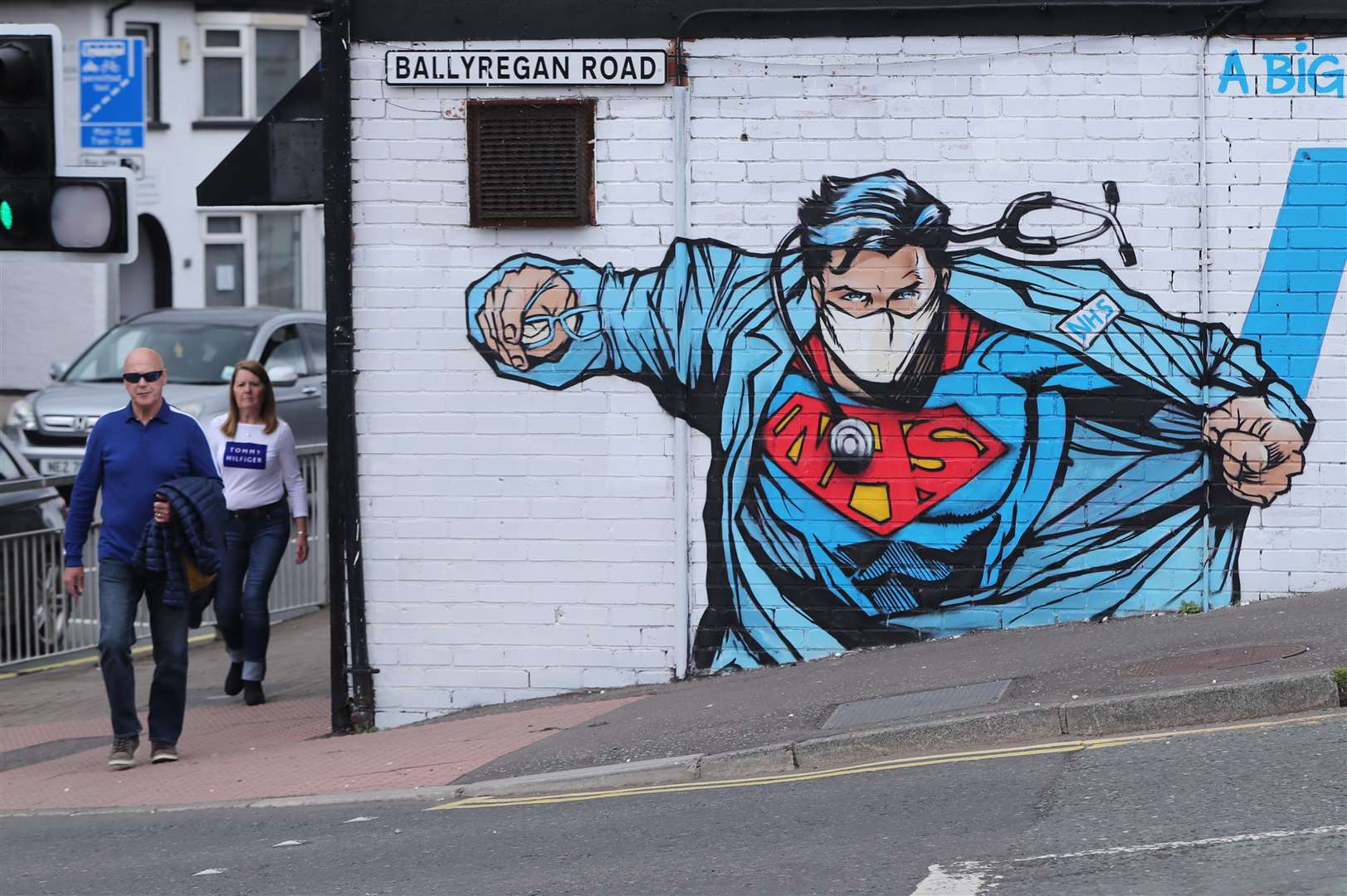 People walk past street art supporting the NHS near to the Ulster Hospital on the outskirts of Belfast (Niall Carson/PA)