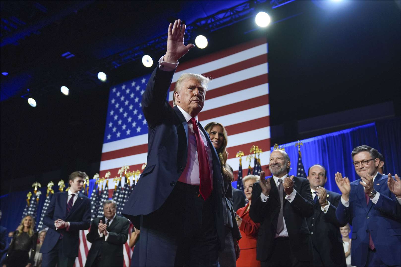 Donald Trump waves as he walks with wife Melania at his election night party at the Palm Beach Convention Centre (Evan Vucci/AP)