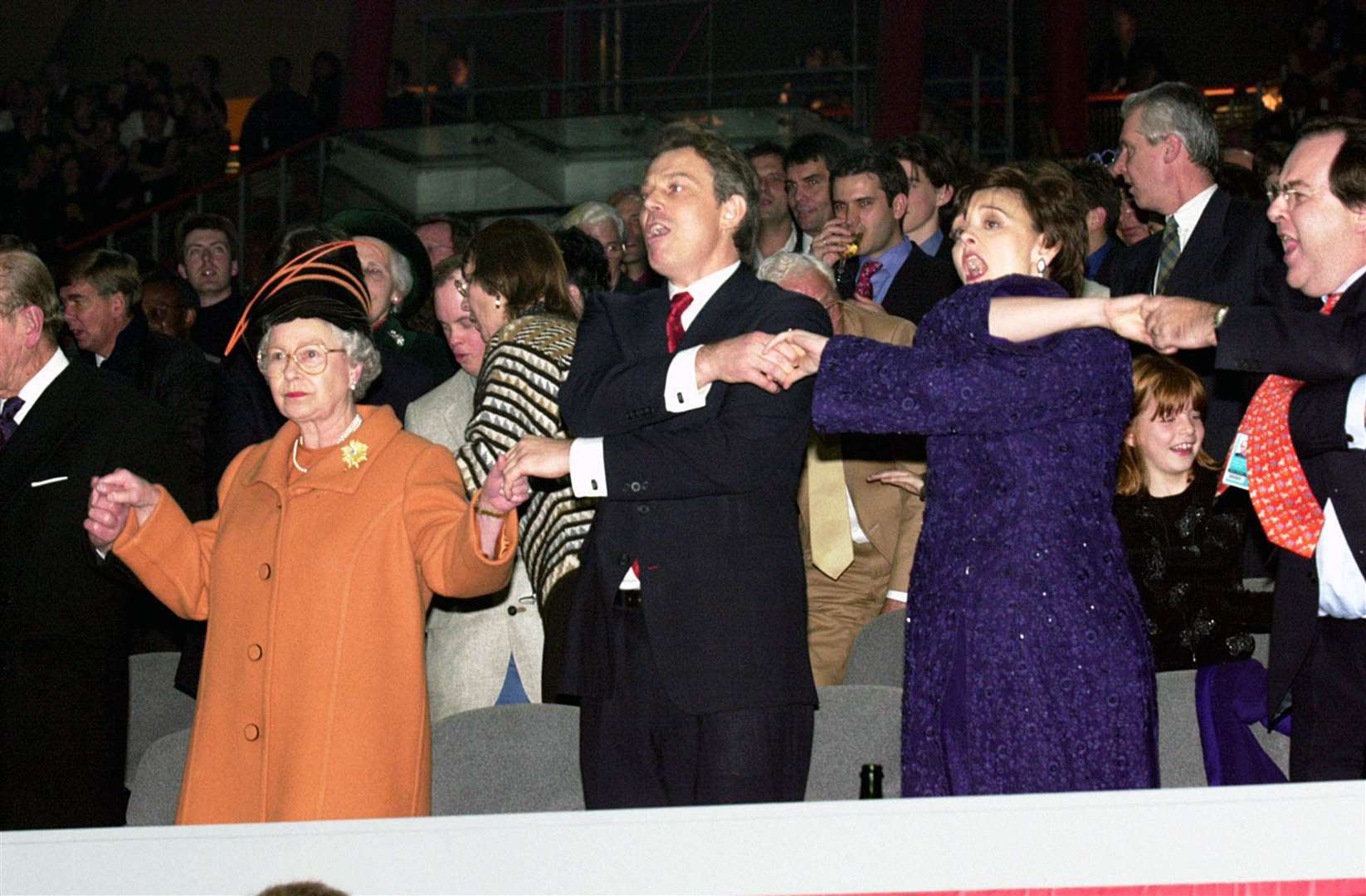 The Queen joins Prime Minister Tony Blair and wife Cherie during the singing of Auld Lang Syne at the millenium New Year’s Eve celebrations (PA)