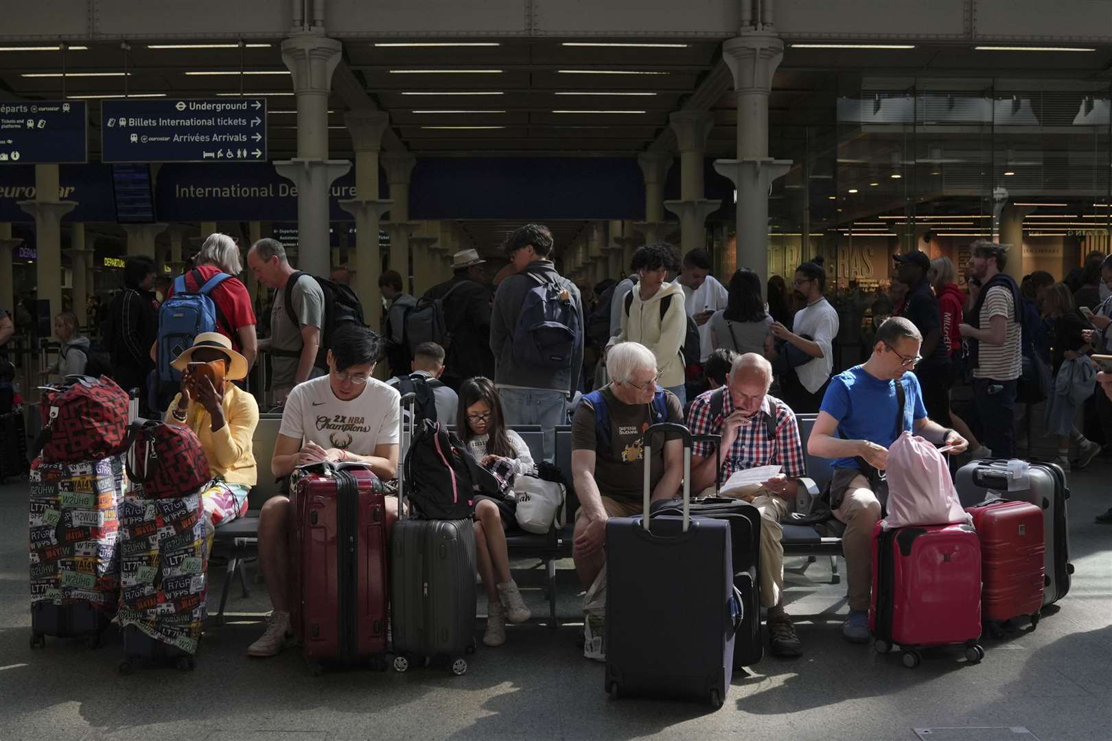 Families wait with luggage for the next departure (Maja Smiejkowska/PA)