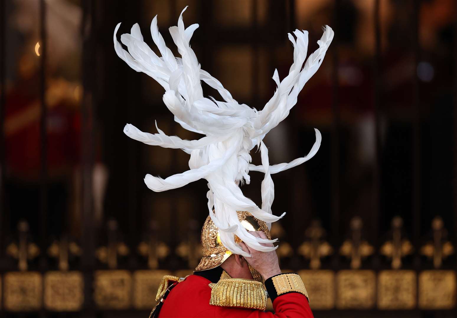A member of the King’s Body Guards of the Honourable Corps of Gentlemen at Arms arrives at a windy Palace of Westminster (Daniel Leal/PA)