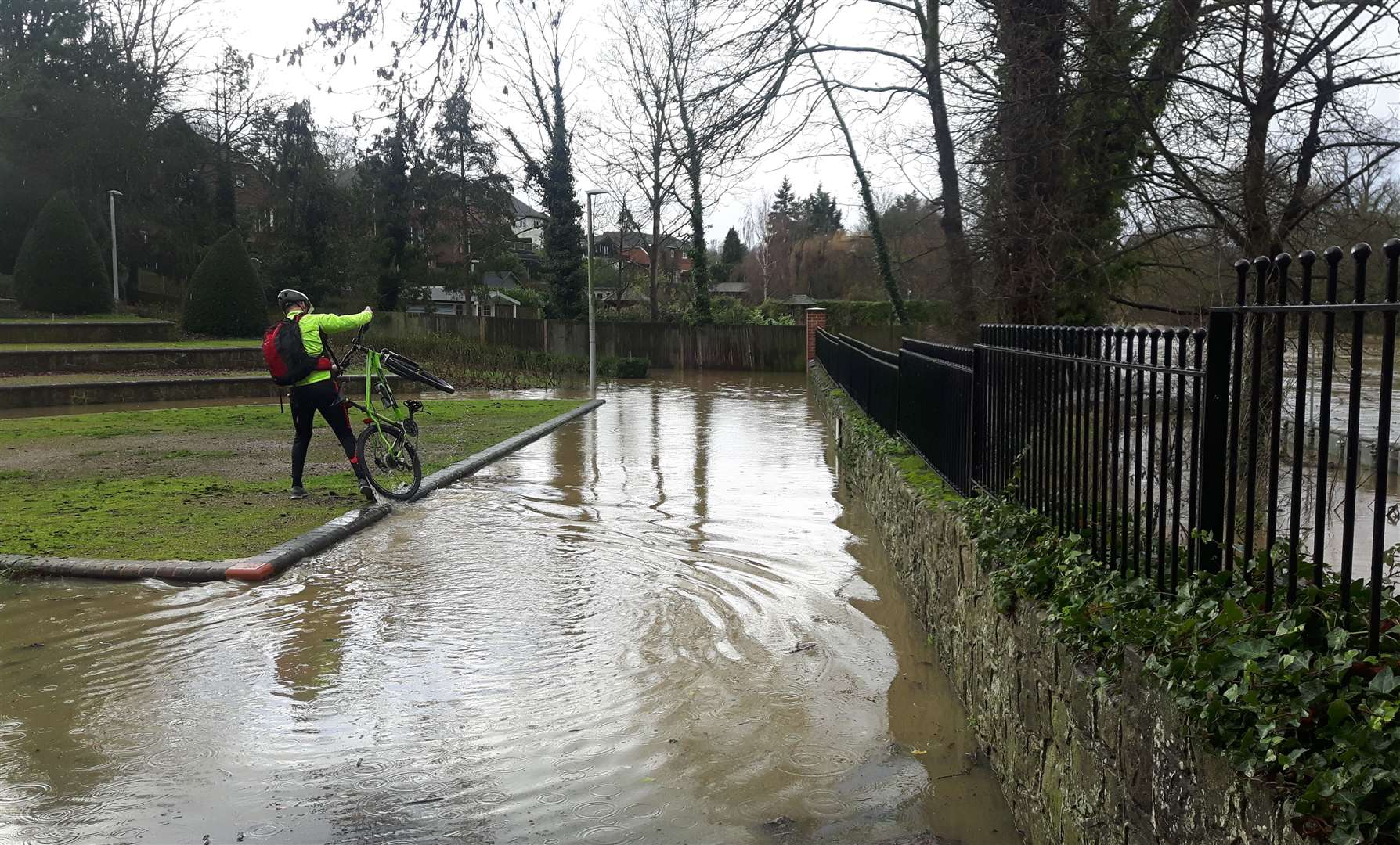 A cyclist carries their bike