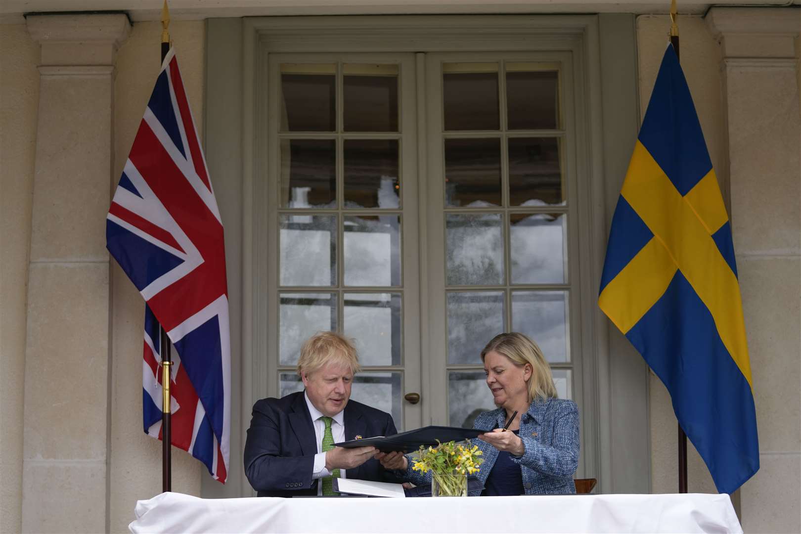 Boris Johnson and Swedish prime minister Magdalena Andersson exchange files as they sign the security assurance (Frank Augstein/PA)