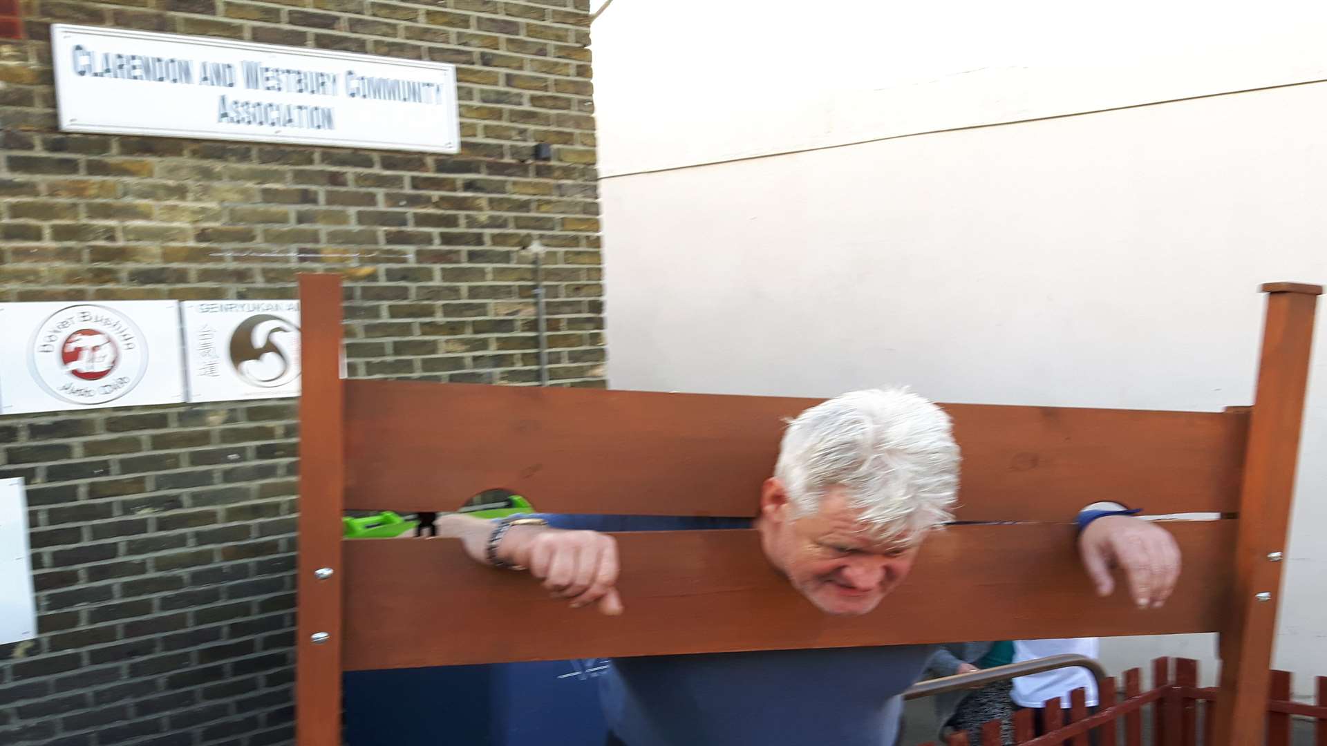 Reporter Sam Lennon in the stocks for a Kelly Turner fundraising event.