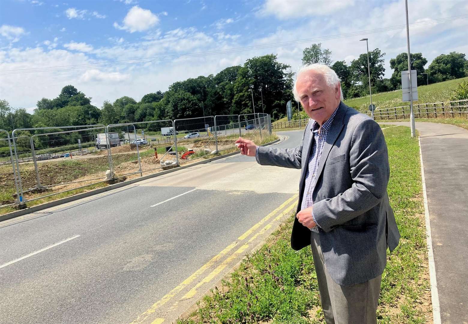 Borough councillor Denis Spooner points to the suspended widening works on the A249