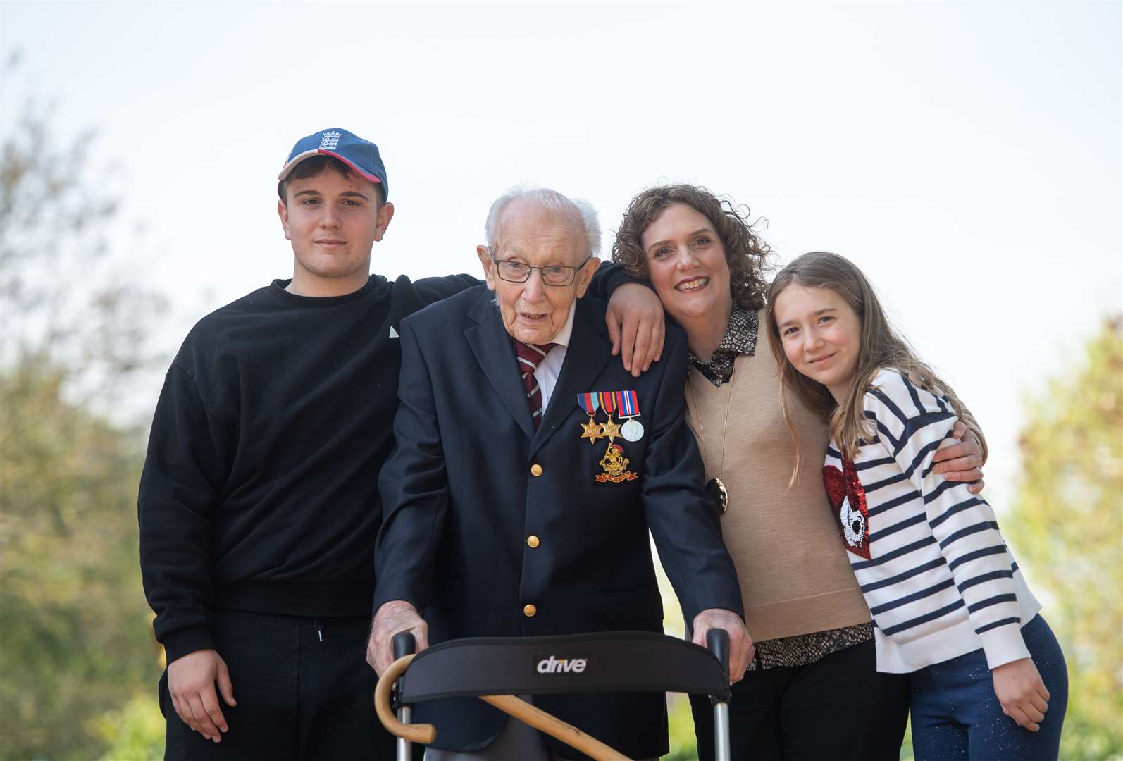 Cpt Moore, with (from left) grandson Benji, daughter Hannah Ingram-Moore and granddaughter Georgia, at his home in Marston Moretaine (Joe Giddens/PA)