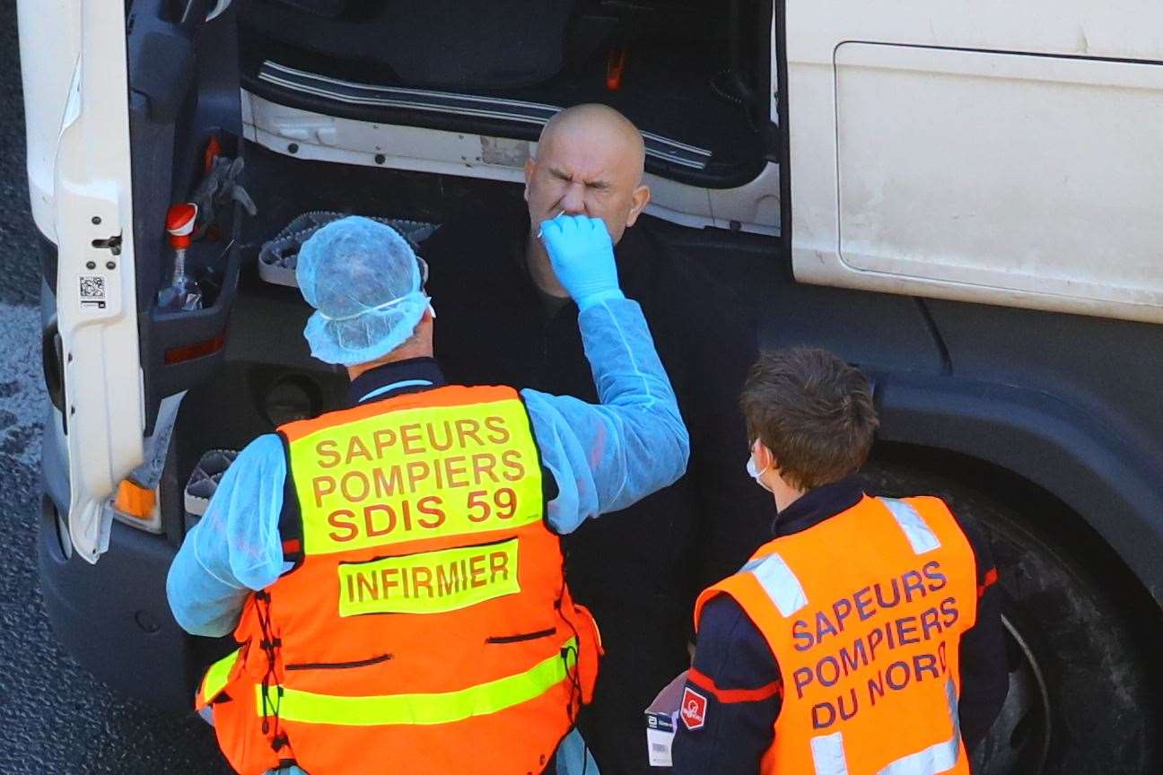 A French firefighter deployed to the UK conducts a Covid-19 test on a driver at the Port of Dover, Kent (Aaron Chown/PA)