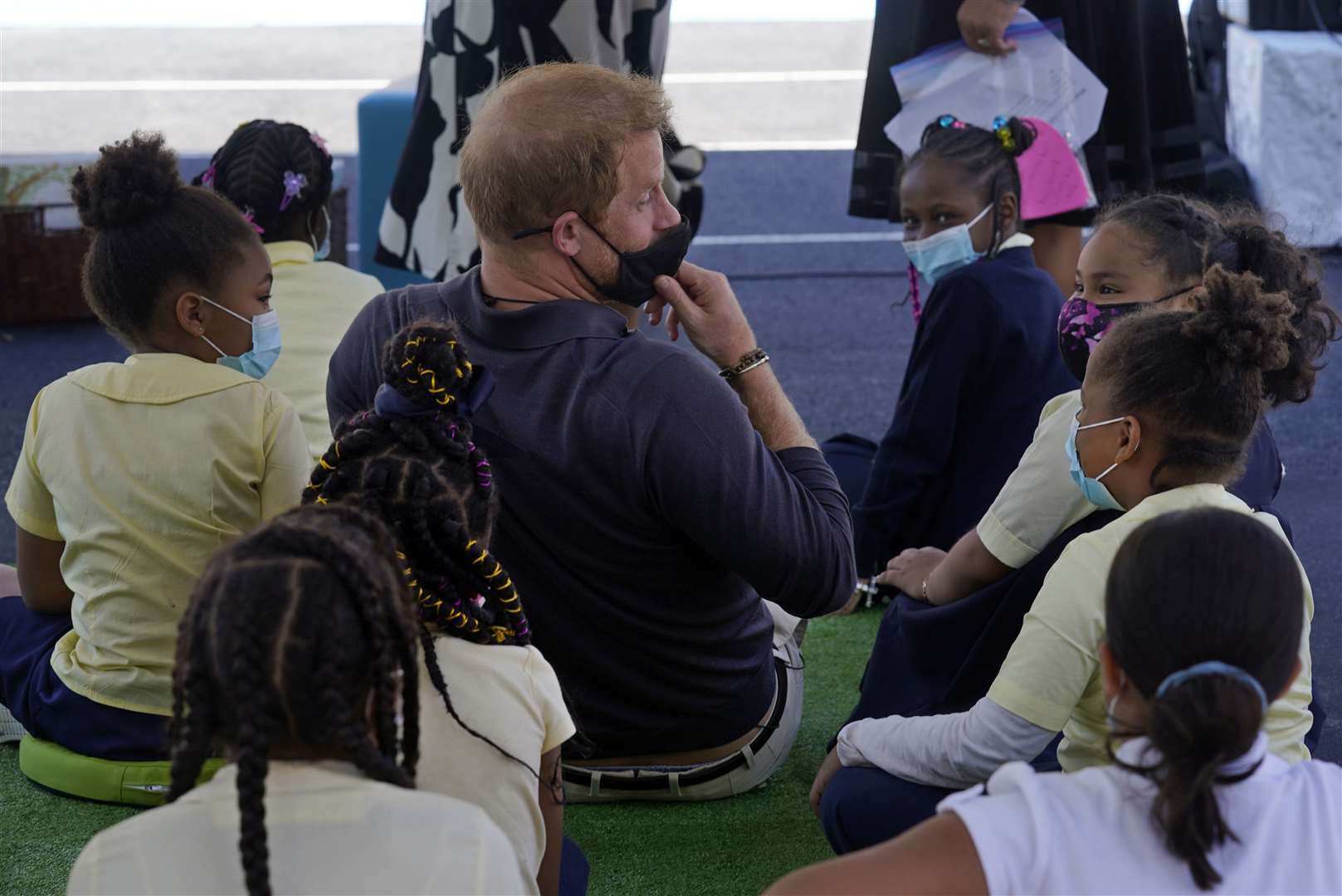 Harry adjusts his mask as he sits among students (Richard Drew/AP)