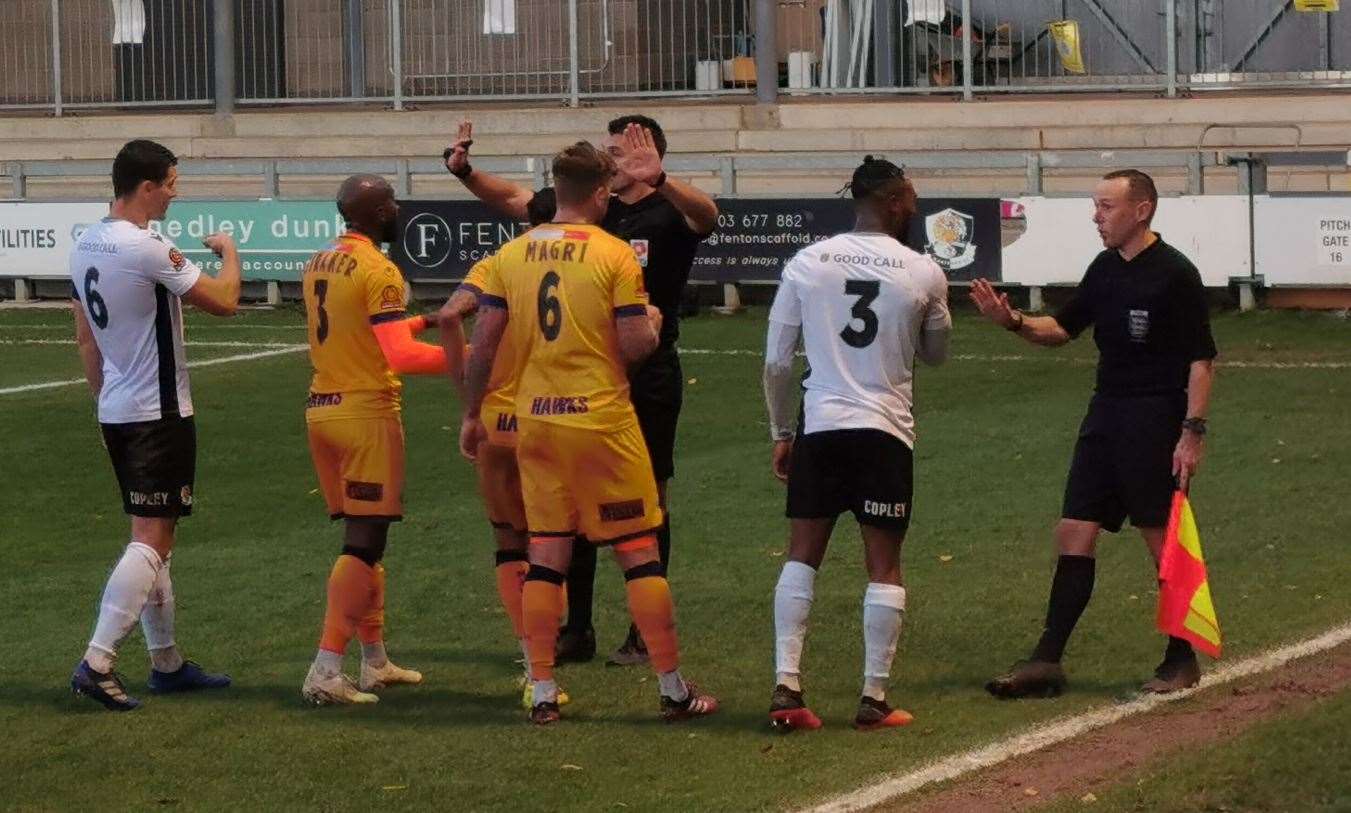 Dartford and Havant players make their point to referee Callum Walchester and his assistant. (42935409)