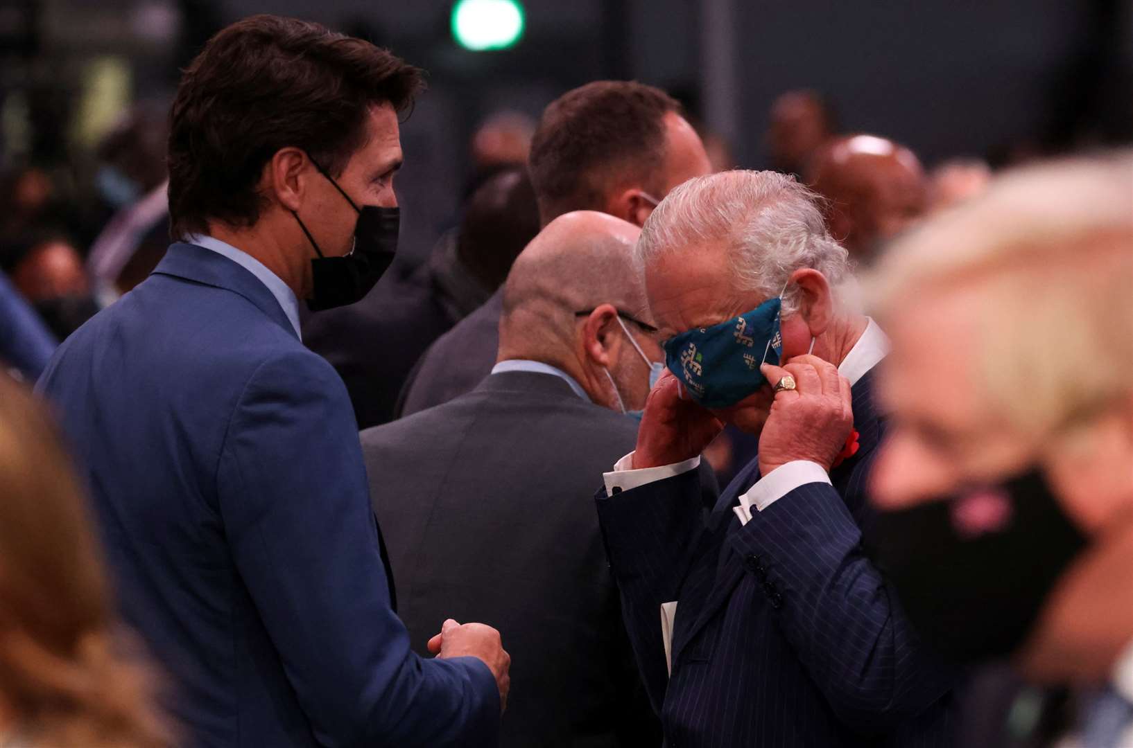 The Prince of Wales adjusts his face mask next to Canada’s prime minister Justin Trudeau (Yves Herman/PA)