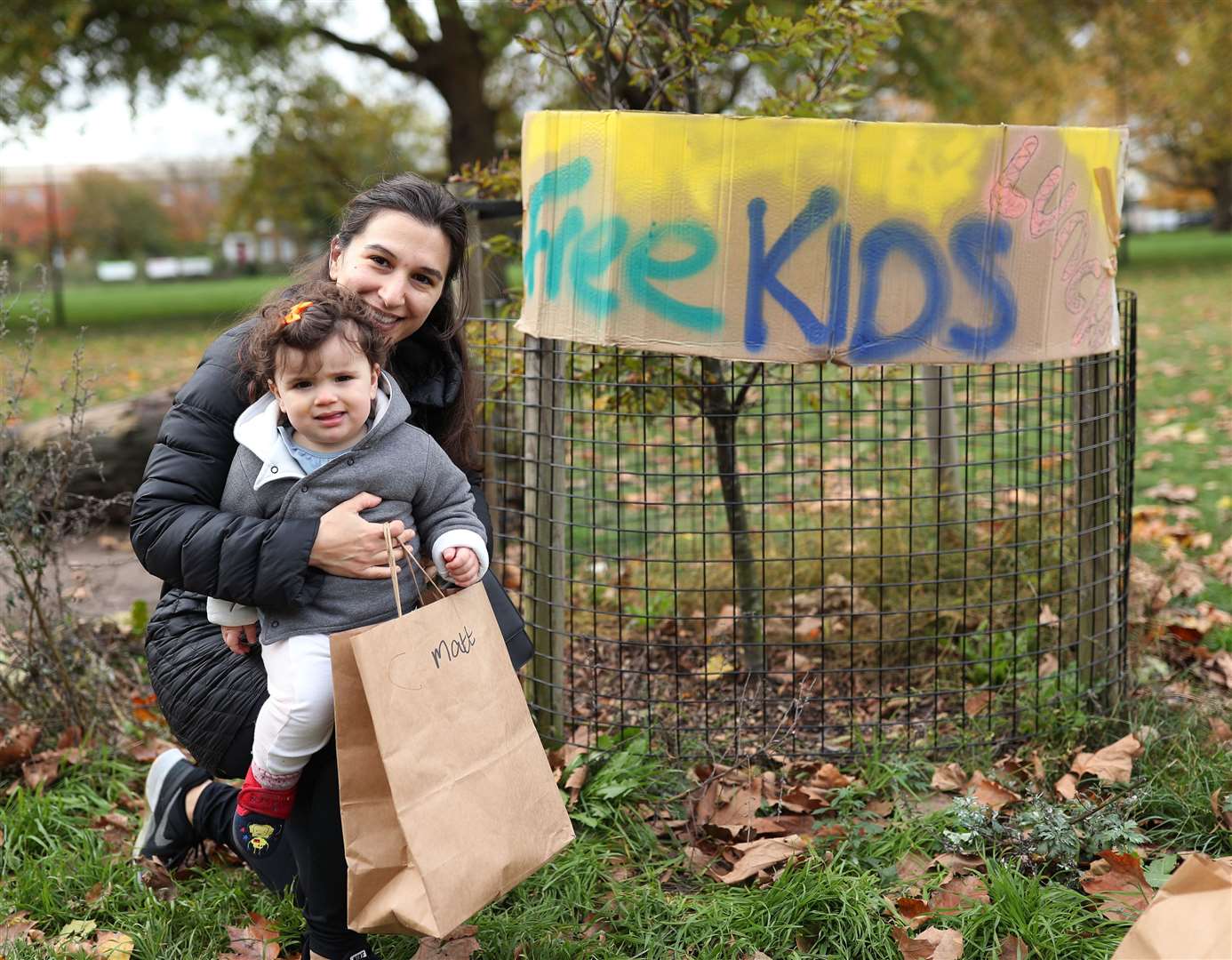 Lucy Turpin and her 11-month-old baby Sophie with a bag of food provided by volunteers in London Fields, east London (Yui Mok/PA)