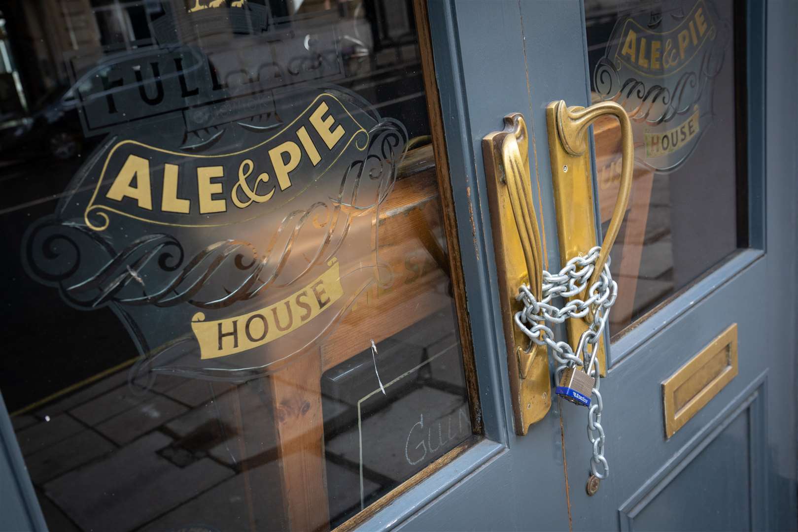 Chains secure the doors of a closed Fuller’s pub in London, during England’s third national lockdown to curb the spread of coronavirus (Dominic Lipinski/PA)