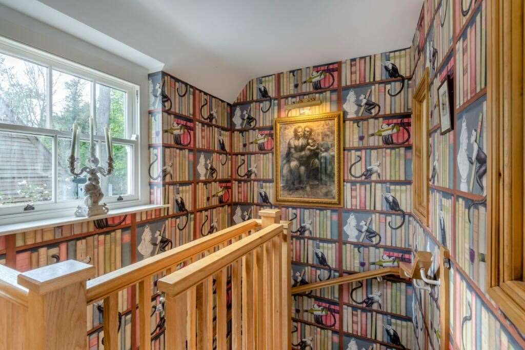 One stairwell is covered with bookcase wallpaper. Picture: Strutt and Parker