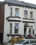 Firefighters outside the fire damaged building. Picture: PETER BARNETT