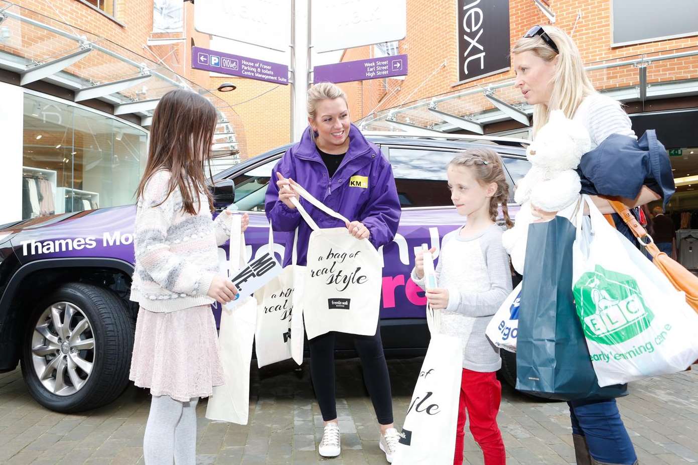 Tracy Gilmore and youngsters Darcey Gilmore, 6, and Jessica Ryan, 8 receive a bag