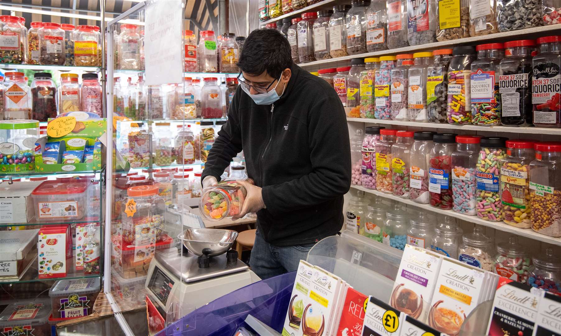 Rakesh Parmer weighs out sweets at Ye Olde Sweet Shoppe in Leicester (Joe Giddens/PA)