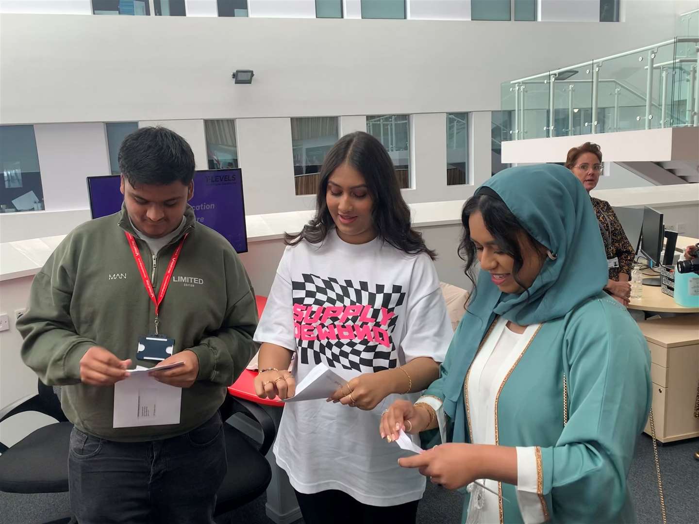 Friends Aqsah Ahmed, right, and Eshana Kainth, centre, open their results (Josh Payne/PA)