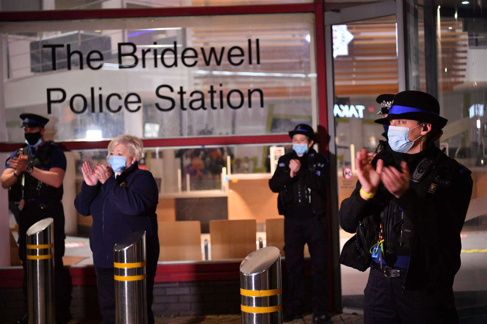 Police officers clap outside the Bridewell police station in Bristol city centre (Ben Birchall/PA)