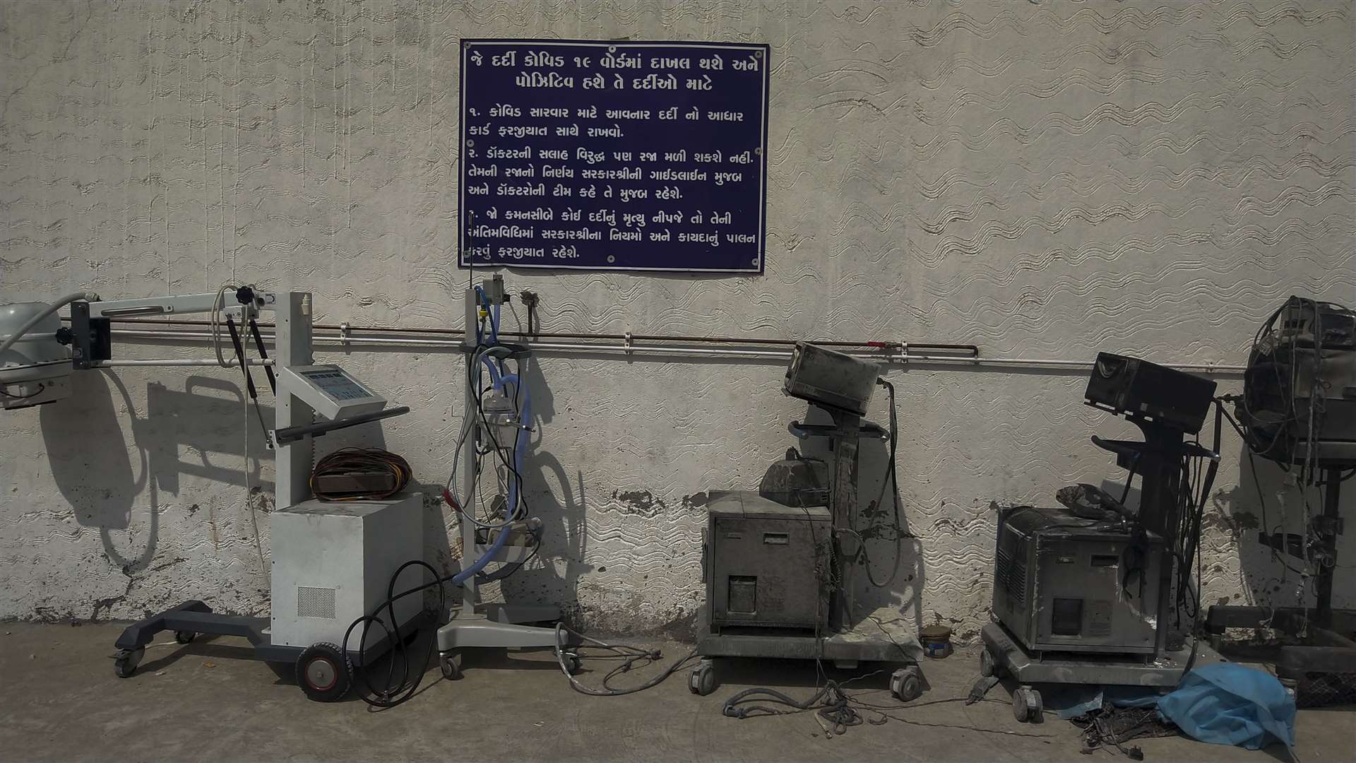 Instructions for Covid-19 patients are seen on signage in Gujarati next to damaged equipment after a deadly fire at the Welfare Hospital in Bharuch (Viral Rana/AP)