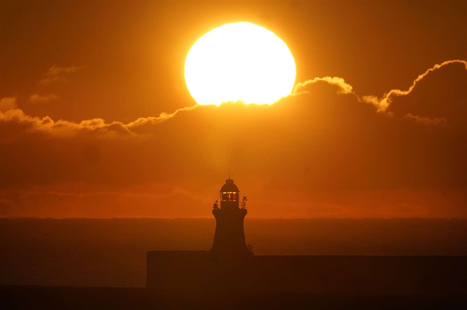 The sun rises over South Shields lighthouse on the north east coast (Owen Humphreys/PA)