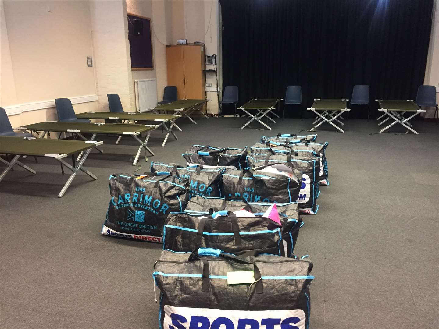 Volunteers at the Winter Shelter set up the camp beds for guests, and bedding and spare clothes are left in the middle of the room