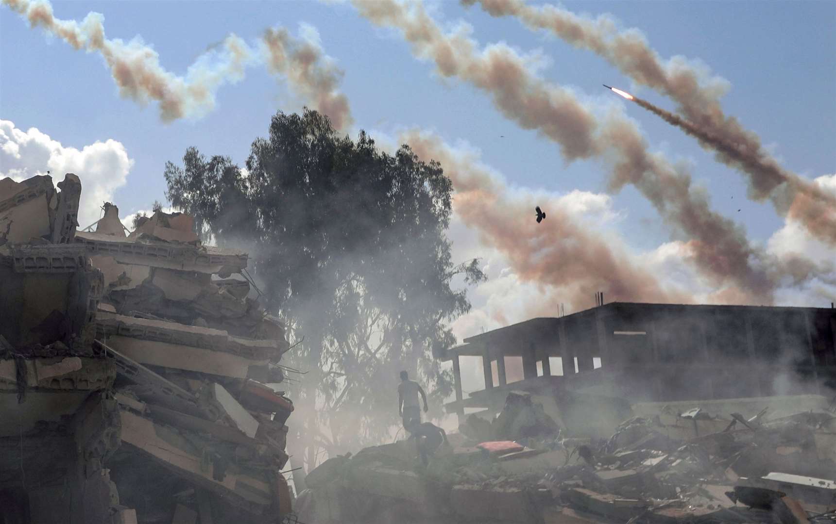 Rockets are fired from the Gaza Strip toward Israel over destroyed buildings following Israeli airstrikes on Gaza City. Picture: Mohammed Dahman/AP