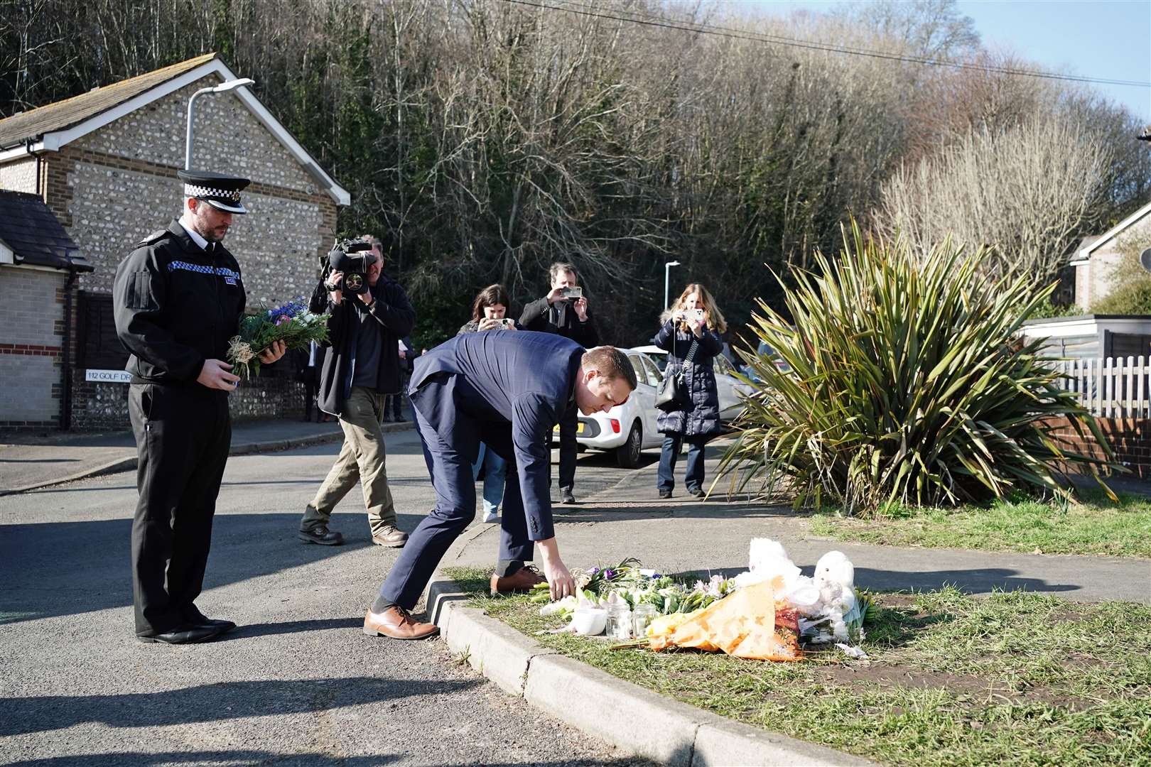 Metropolitan Police Detective Superintendent Lewis Basford (centre) and Sussex Police Chief Superintendent James Collis (left) pay their respects at a tribute on Golf Drive in Brighton, East Sussex, on Thursday (Jordan Pettitt/PA)