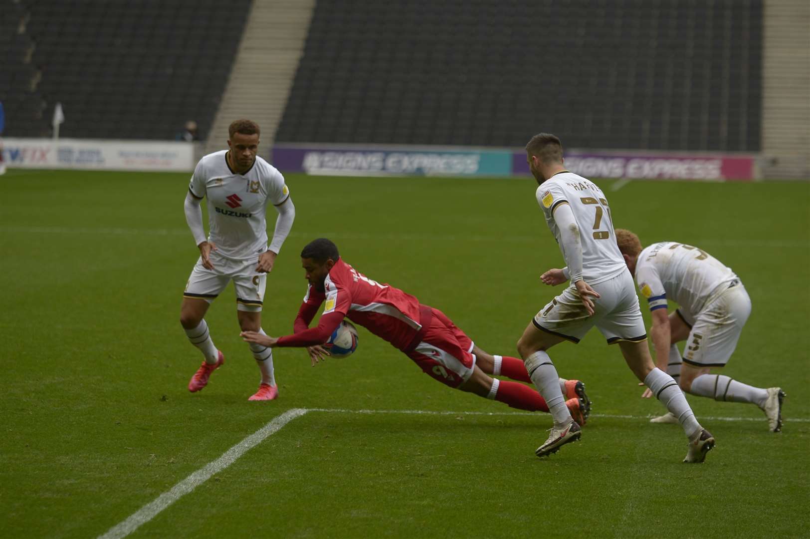 Dominic Samuel is pushed over in the MK penalty area Picture: Barry Goodwin (42744227)