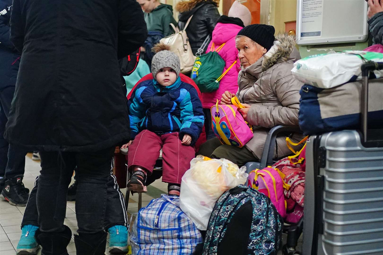 A family from Ukraine wait with their luggage at Przemysl train station in Poland (Victoria Jones/PA)