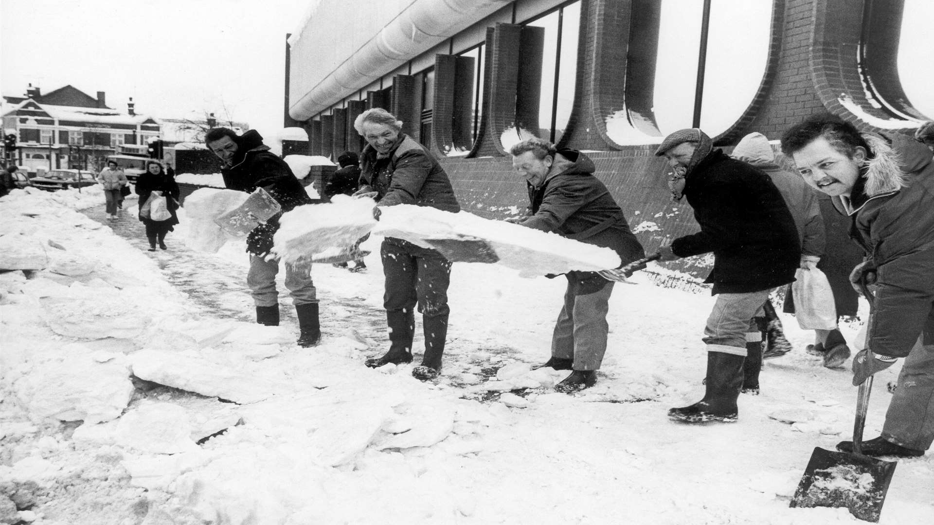 Friends have fun while shovelling snow