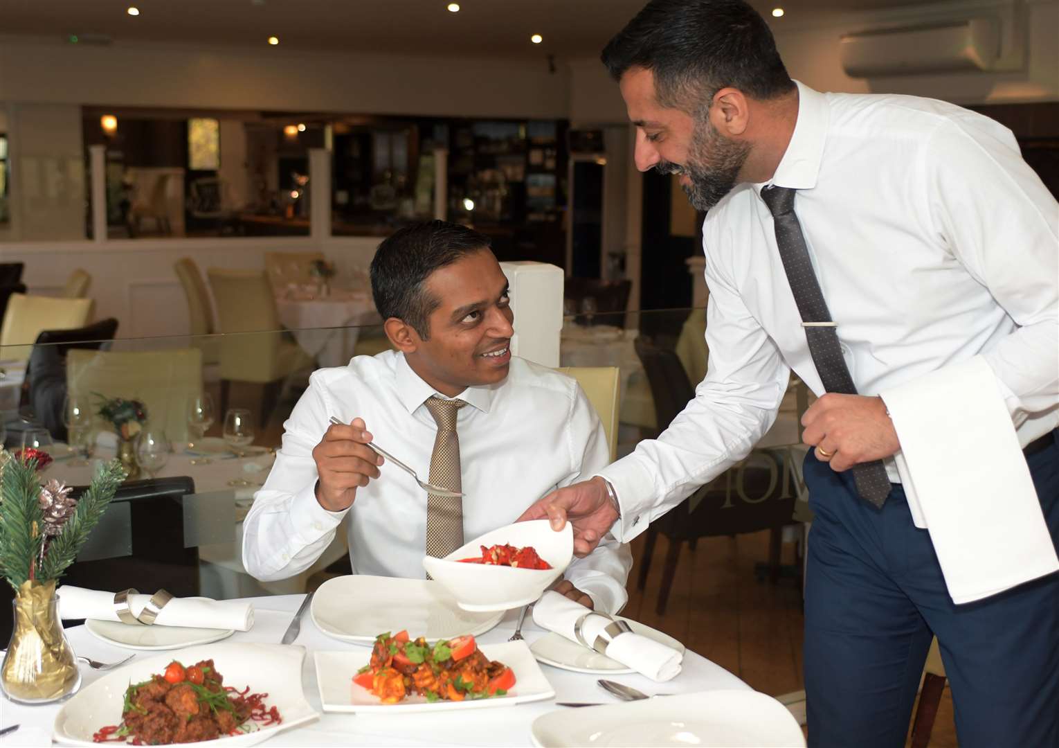Habib Siddiq of The Cinnamon Square, left, is served one of his own dishes