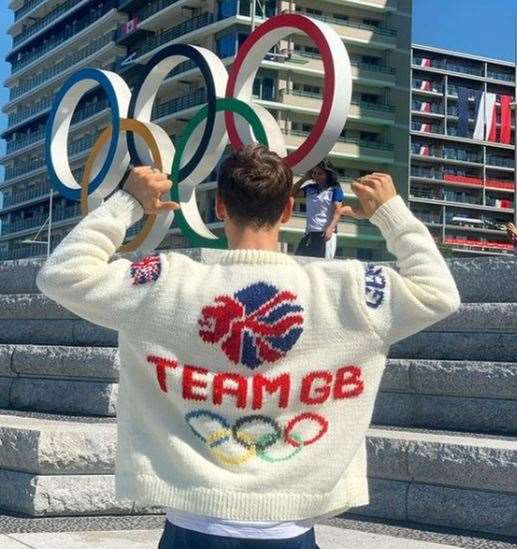 Photo taken with permission from the Instagram account @madewithlovebytomdaley of Tom Daley wearing an Olympic-themed cardigan he knitted whilst sitting in the stands at the Olympics (PA Media)