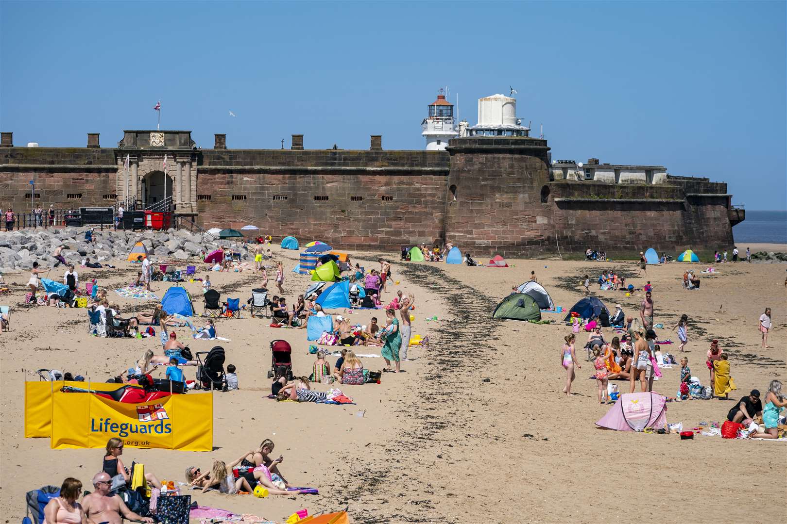 Sunbathers enjoy the weather in New Brighton, Wirral, on what could be the hottest day of the year (Peter Byrne/PA)