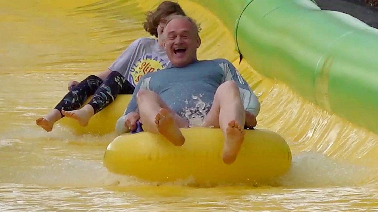 Sir Ed Davey speeds down the Ultimate Slip n Slide attraction near Frome, Somerset (Rod Minchin/PA)