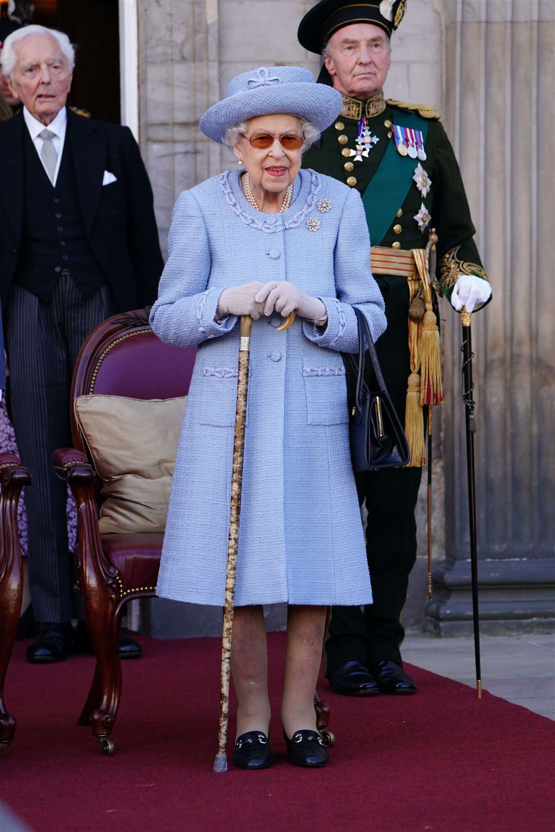 The Queen used a stick as she watched the parade in the grounds of the Palace of Holyroodhouse (Jane Barlow/PA)