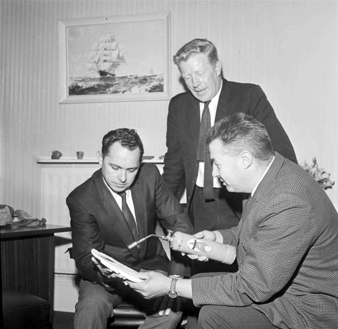 A demonstration from 1969 of the fire-resistant qualities of asbestos, as three men try to set an asbestos panel alight with a blow-torch