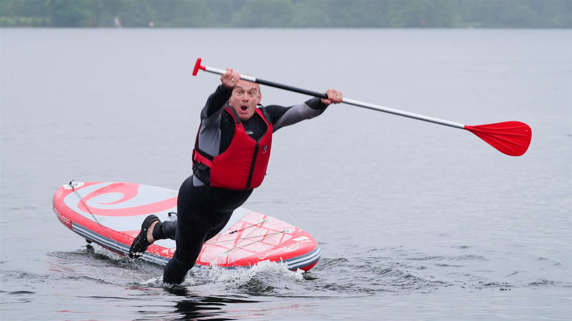 Liberal Democrat Leader Sir Ed Davey falling into the water while paddleboarding on Windermere, while on the General Election campaign trail (Peter Byrne/PA)