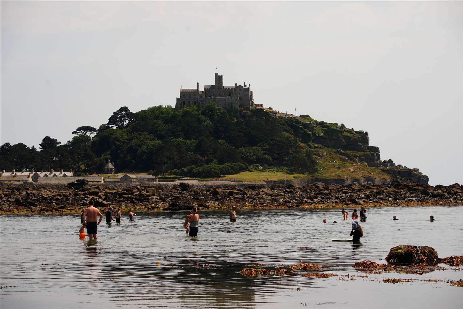 People cooling down in the sea at St Michael’s Mount in Cornwall (Ben Birchall/PA)