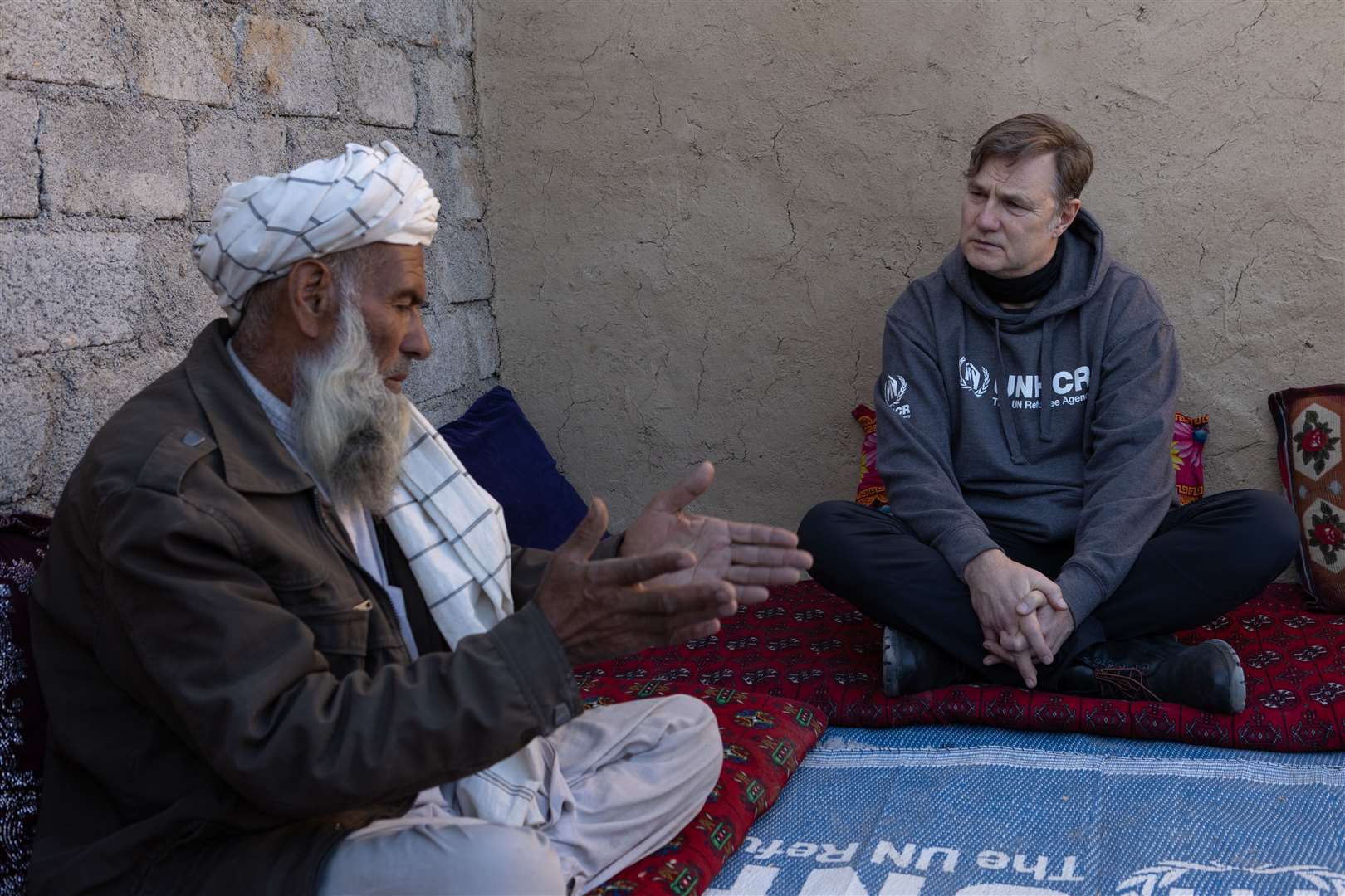 Morrissey speaking to Haji Khan Gul whose home was damaged by the floods in Pakistan earlier this year (UNHCR/Andy Hall/PA)