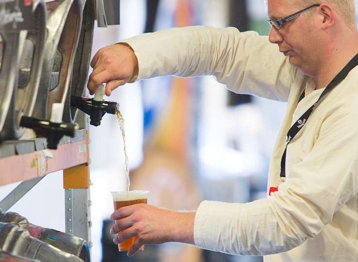 A beer lover pours an ale at the Kent County Show in Detling