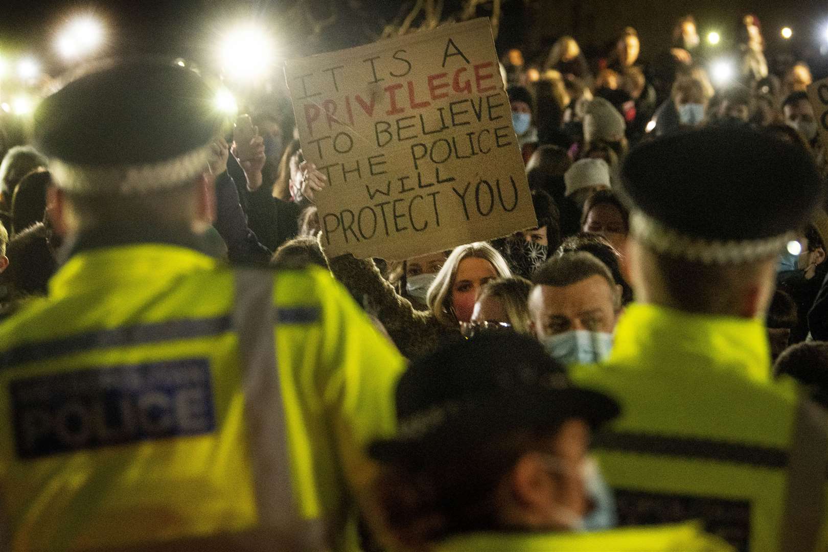 A woman holds up a placard as people gather for the Sarah Everard vigil in Clapham Common (Victoria Jones/PA)